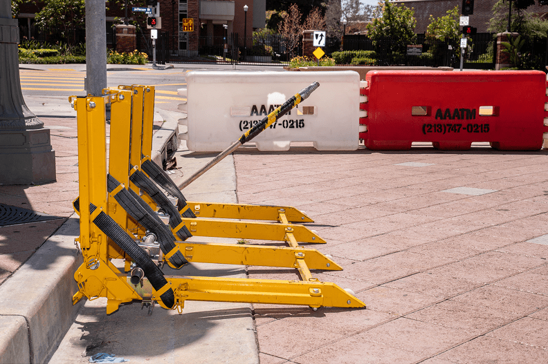 Yellow parking barriers on urban sidewalk.